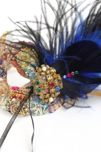 Bespoke Jewelled mask decorated with black and blue ostrich feathers and a vintage gold brooch with coloured Swarovski crystals